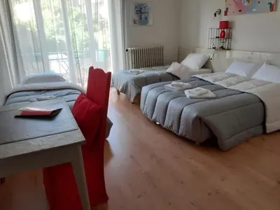a room with two beds and a couch and a table at Hotel Bayle in Belcaire