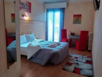a bedroom with a bed and a table with red chairs at Hotel Bayle in Belcaire