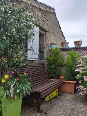 a wooden bench in front of a building with plants at Riverside Home Cottage in Trèbes