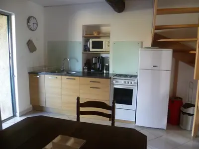 a kitchen with a white refrigerator and a stove at Les Fenals in Fitou