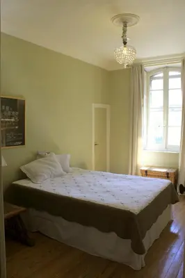 a bedroom with a bed and a chandelier at B&B Coup de Coeur in Bram