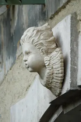 a plaster bust of a child on the side of a building at B&B Coup de Coeur in Bram