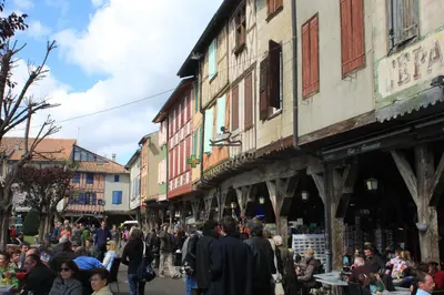 a crowd of people walking down a street with buildings at B&B Coup de Coeur in Bram