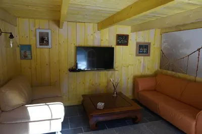 a living room with two couches and a tv at Le Clos des Troubadours in Pennautier