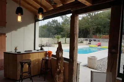 a kitchen with a bar and a swimming pool at Le Clos des Troubadours in Pennautier