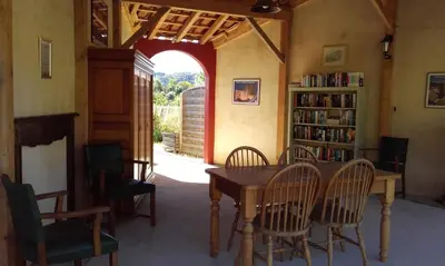 a dining room with a table and chairs and a book shelf at gîtes 