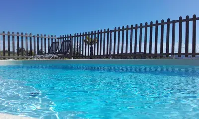 a swimming pool in front of a fence at gîtes 