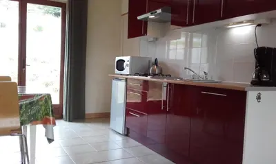 a kitchen with red cabinets and a white microwave at gîtes 