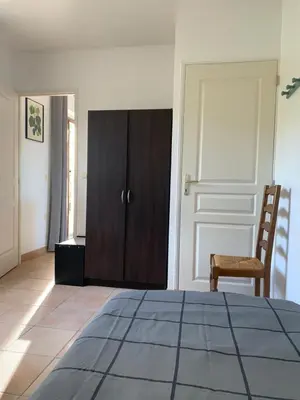 a bedroom with a wooden cabinet and a chair at gîtes 