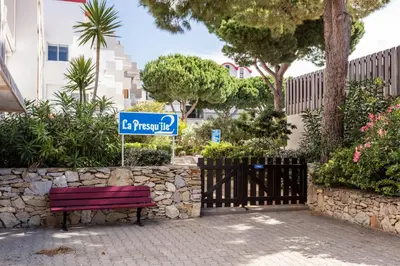 a street sign sitting next to a bench at Studio La Presqu'île 2 in Gruissan