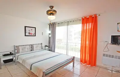 a bedroom with a bed and a large window at Studio La Presqu'île 2 in Gruissan