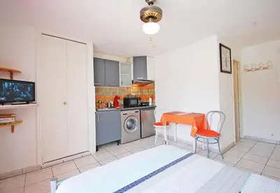 a kitchen with a table and a washing machine at Studio La Presqu'île 2 in Gruissan