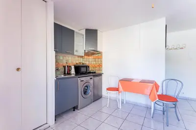 a kitchen with a table and a washing machine at Studio La Presqu'île 2 in Gruissan