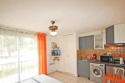a kitchen with a washing machine and a window at Studio La Presqu'île 2 in Gruissan