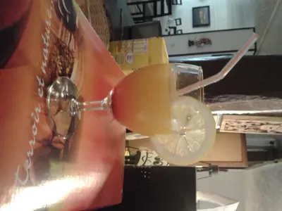 a drink in a wine glass with a lemon slice at Le Baudilois in Pont-de-Larn