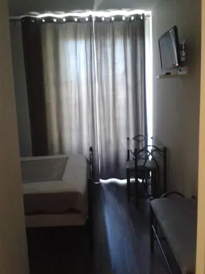 a bedroom with two beds and a window with curtains at Le Baudilois in Pont-de-Larn