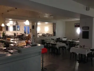 a dining room with tables and chairs in a restaurant at Le Baudilois in Pont-de-Larn