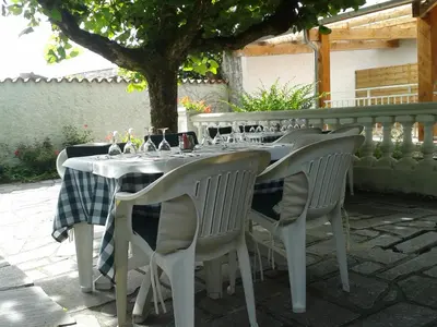 a table with chairs and wine glasses on it at Le Baudilois in Pont-de-Larn
