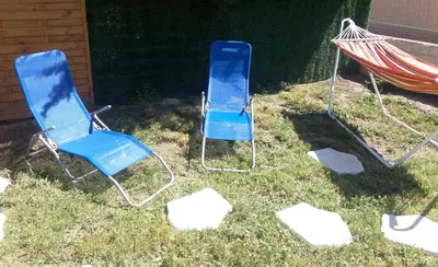 two blue chairs and a hammock in the grass at Petite Chouette in Salses-le-Chateau