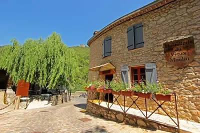 a stone building with flower boxes on the side of it at Hostellerie du Vieux Moulin in Duilhac