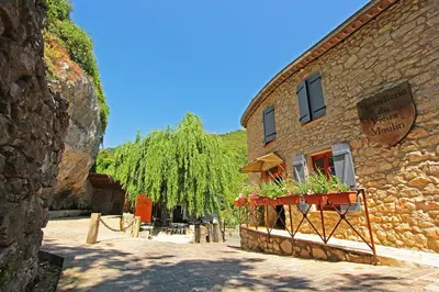 a stone building with a flower planter on it at Hostellerie du Vieux Moulin in Duilhac