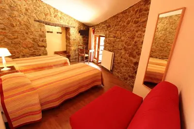 a hotel room with two beds and a red couch at Hostellerie du Vieux Moulin in Duilhac