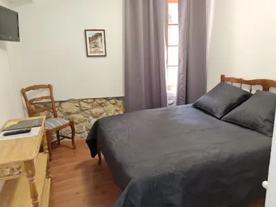 a bedroom with a bed and a table and a chair at Hostellerie du Vieux Moulin in Duilhac