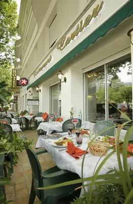a table with plates of food on a patio at Logis Hôtel Cartier in Quillan