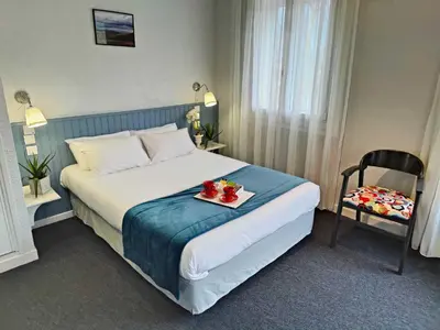 a hotel room with a bed with a tray of fruit on it at Logis Hôtel Cartier in Quillan