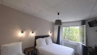 a bedroom with a white bed and a window at Hôtel Restaurant Mas Le Châtelet in Saint-Paul-de-Fenouillet