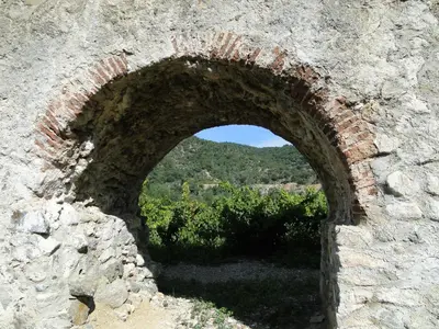 an arch in a brick wall with a view at Hôtel Restaurant Mas Le Châtelet in Saint-Paul-de-Fenouillet