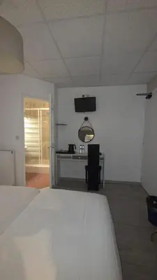 a bedroom with a white bed and a desk at Hôtel Restaurant Mas Le Châtelet in Saint-Paul-de-Fenouillet