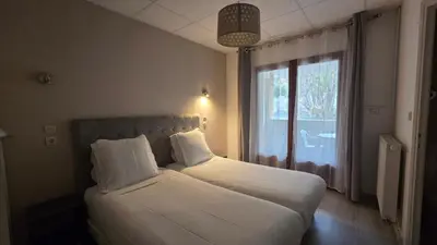 a bed in a room with a large window at Hôtel Restaurant Mas Le Châtelet in Saint-Paul-de-Fenouillet