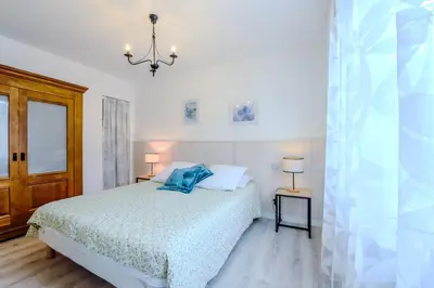 a bedroom with a bed and a chandelier at Les Gîtes de Nathalie: Corneille et Rivals in Carcassonne