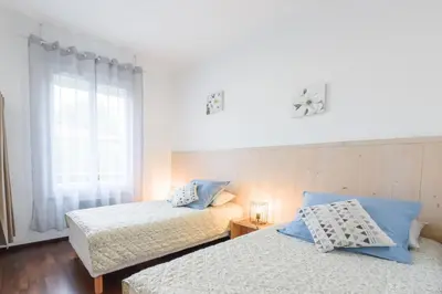 a bedroom with two beds and a window at Les Gîtes de Nathalie: Corneille et Rivals in Carcassonne