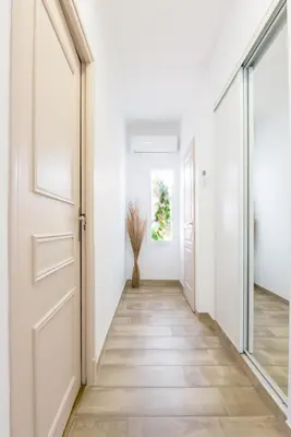 an empty hallway with an open door and a vase on the floor at Les Gîtes de Nathalie: Corneille et Rivals in Carcassonne