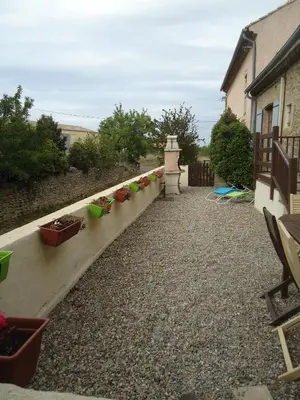 a garden with potted plants on a retaining wall at Domaine de la Pinsonnière in La Livinière