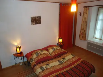 a bedroom with a bed and two lamps on tables at Domaine de la Pinsonnière in La Livinière