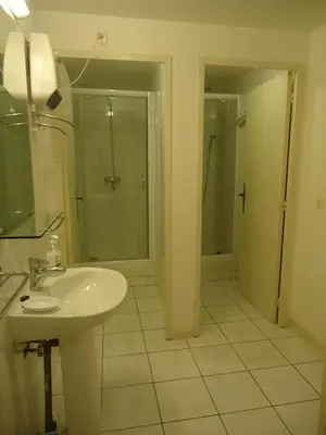 a white bathroom with a sink and a shower at Domaine de la Pinsonnière in La Livinière