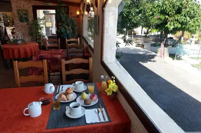 a table with a plate of food on a balcony at Logis Hôtel LE PRESSOIR in Saint-Chinian