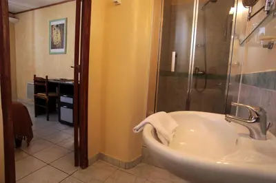 a bathroom with a tub and a shower and a sink at Logis Hôtel LE PRESSOIR in Saint-Chinian