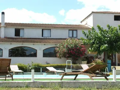 a group of chairs sitting in front of a building at Logis Hôtel LE PRESSOIR in Saint-Chinian