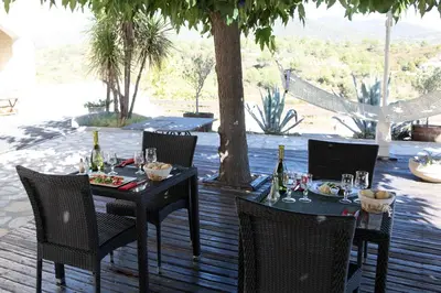 a table and chairs with wine bottles on a patio at Logis Hôtel LE PRESSOIR in Saint-Chinian