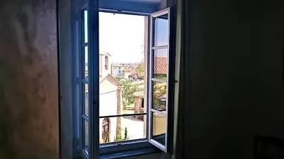 an open window with a view of a city at Le Neptune in Le Somail