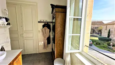 a bathroom with a window and a sink at Le Neptune in Le Somail
