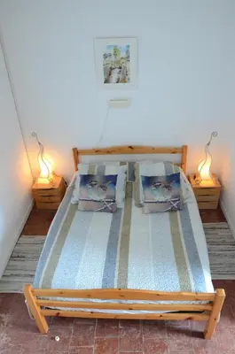 a bed in a room with two lamps on the floor at Le Neptune in Le Somail