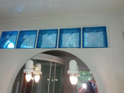 four blue glass windows on a wall with a mirror at Apartment Albert parking privé gratuit in Limoux