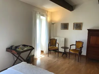 a bedroom with two chairs and a table and a bed at Le Jardin d'Homps in Homps