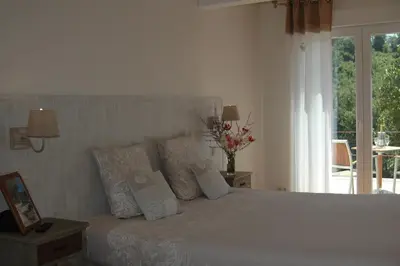 a bedroom with a white bed with pillows and a window at Les Jardins de Soulane B&B - Adults only in Belcastel-et-Buc