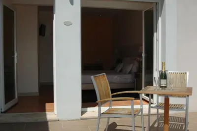 a table and two chairs and a table and a bed at Les Jardins de Soulane B&B - Adults only in Belcastel-et-Buc
